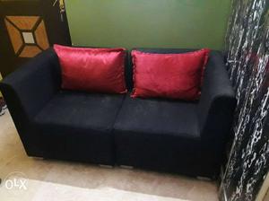 Black Fabric Sofa With Red Throw Pillows