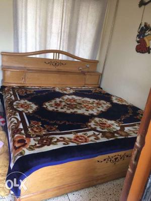 Brown Wooden Bed With Blue White And Brown Floral Bed Sheet