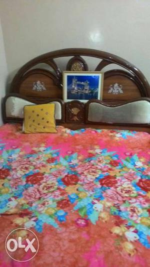 Brown Wooden Bed And Floral Bed Sheet