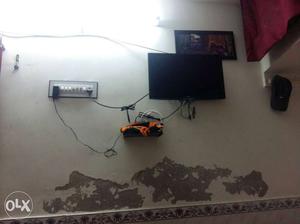 Black Flat Screen Television And White Multi Plug
