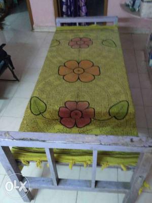 Gray Wooden Bed Frame With Green Bed Sheet. 2 cots cost 6k