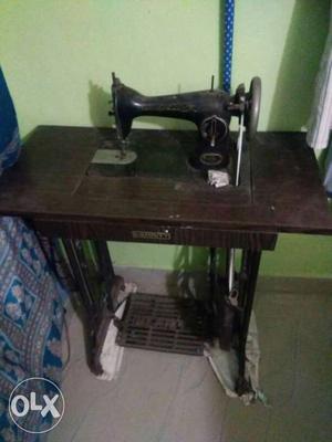 Black Manual Sewing Machine And Wooden Desk