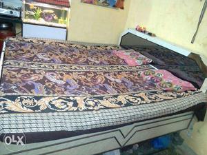 White Wooden Bed With Purple Brown And Blue Floral Mattress