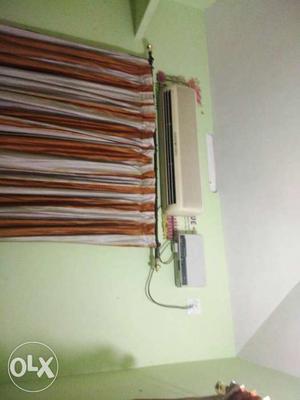 Beige Split-type Ac Unit; White And Brown Window Curtains