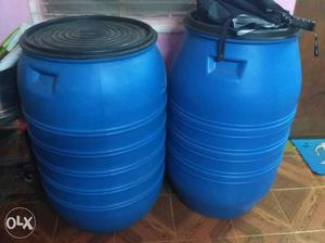 Two Blue And Black Plastic Barrels