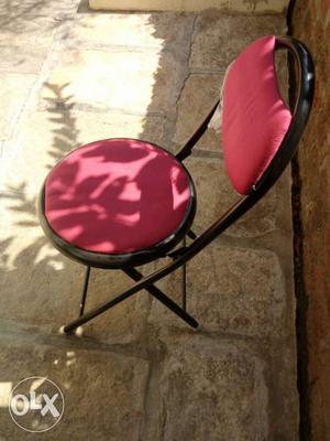 Black Metal Base And Pink Fabric Padded Folding Chair