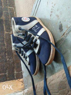 This is a dark blue coloured kids sneakers size