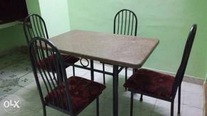 A marble table with 4 chairs dining table.