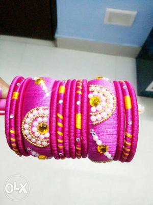 Pink thread bangles decorated with pearls,