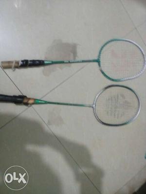 Two Green-and-gray Badminton Rackets