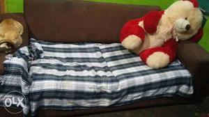 Red And Brown Bear Plush Toy And Gray-and-white Bed Sheet