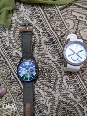 Two Round And Silver Chronograph Watches With Black And
