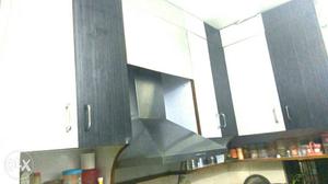 Black And White Wooden Cupboards complete kichen with chimni