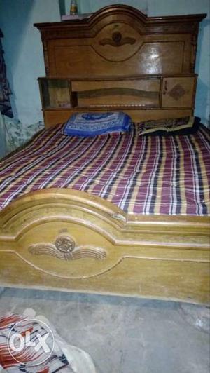Brown Wooden Bed With Maroon, Black, And Brown Plaid Bedding