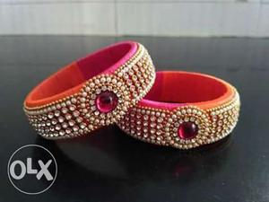 Pair Of Orange Silk Thread Bangles With Red Gemstone And