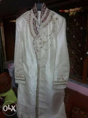 Sherwani in cream and red colour it's really very nice