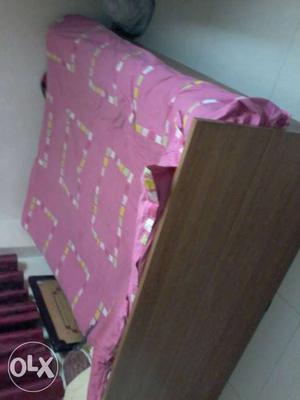 Brown Wooden Bed Frame With Pink Bed Sheet