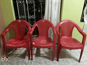 Three Red Plastic Armchairs