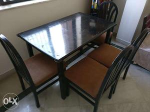 4 seater wooden dining table with four chairs in