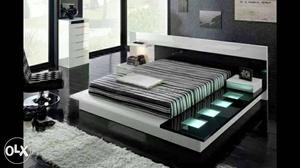 White Wooden Bed With Grey And Black Striped Mattress