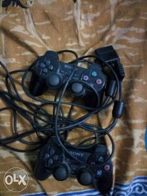 2 Black Sony Game Controllers