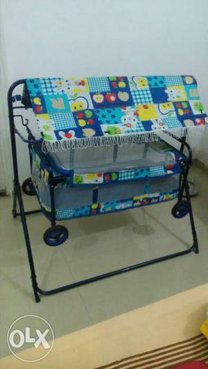 Baby's Blue, Yellow, And Green Printed Cradle