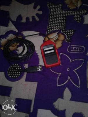 Black And Red Electronic Device With USB Cable