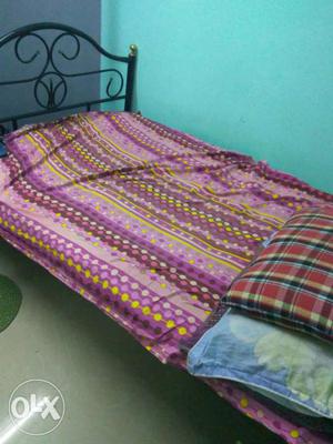 Black Steel Bed Framed With Pink-purple-and-blue Bed Sheet