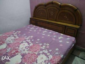 Brown Wooden Headboard With Pink And White Floral Bed Sheet