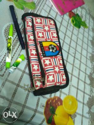 White, Black, And Red Pencil Case With Black Pen