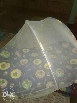 Baby's Blue, Yellow, And Green Bed With Mosquito Net