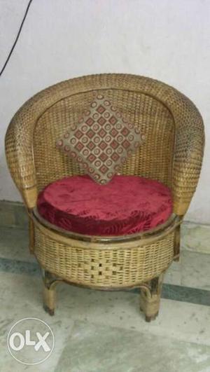 Brown Wicker Armchair With Brown Throw Pillow