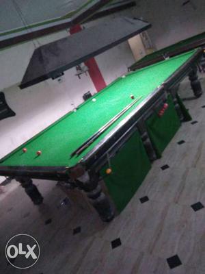 Black And Green Pool Table And Cue Sticks
