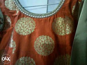 Orange and golden silk like gown with royal work