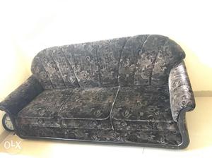 Dark brown sofa with velvet tepestry. It is a