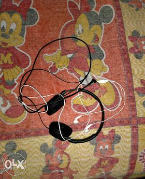White Earphones And Black Corded Headset