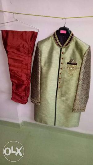 Gold-colored And Black Sherwani With Red Pants