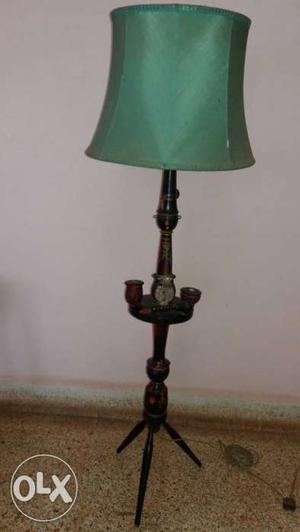 Foldable wooden pedestal lamp in antique design.