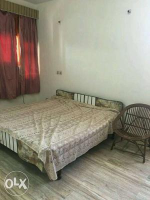 A bed with 2 wooden chairs in a good condition...