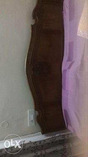 Brown Wooden Bed Headboard And Purple Bed Cover