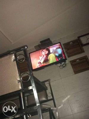 Black Flat Screen Tv And Stainless Steel Legged Brown Wooden