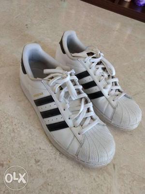 Pair Of White And Black Adidas Low Top Shoes