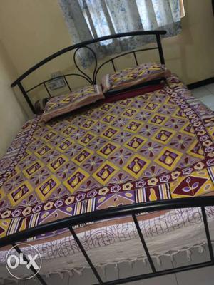 Black Metal Bed With Purple And Yellow Bedspread