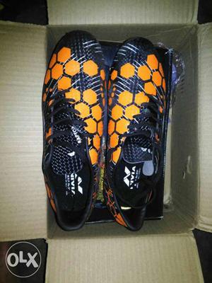 Pair Of Black-and-orange Cleats In Box