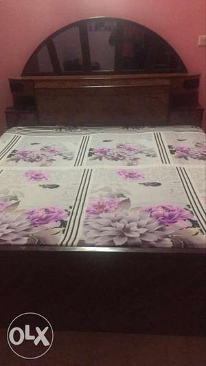 Brown Wooden Bed Frame With Purple And White Floral Padded