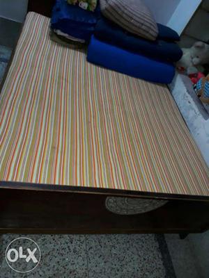 Brown Wooden Bed Frame; Yellow, Red And Beige Bed Mattress