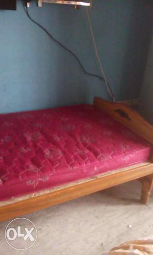 Brown Wooden Platform Bed With Quilted Red Floral Mattress