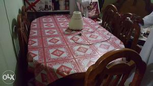 Oval Table With Red And White Tablecloth With Six Brown