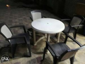 Round White Table With Four Black Good Quality Armchairs