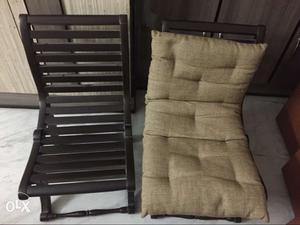 Two Brown Wooden Frame Chairs With One Gray Fabric Cushion
